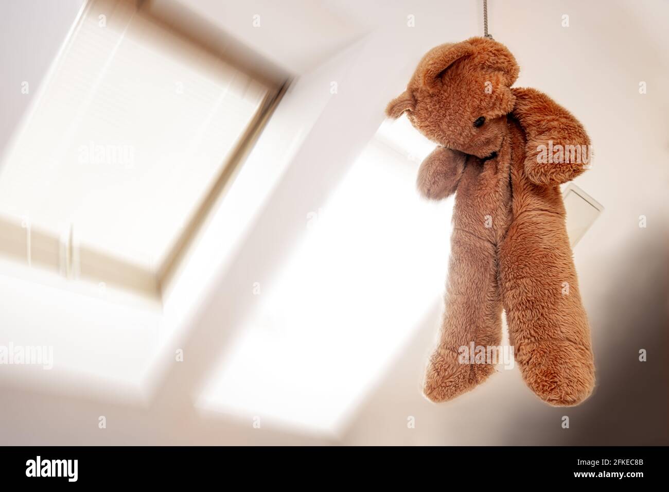 Ein Teddybär hängt in einer Schlinge auf dem Dachboden Zimmer Stockfoto
