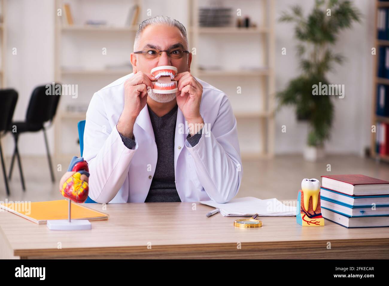 Alte Zahnarztlehrerin sitzt im Klassenzimmer Stockfoto