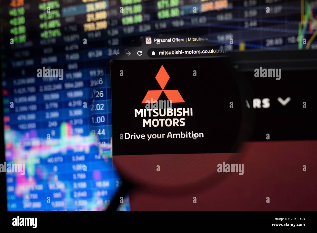 Firmenlogo von Mitsubishi Motors auf einer Website mit verschwommenen Börsenentwicklungen im Hintergrund, die auf einem Computerbildschirm zu sehen sind Stockfoto
