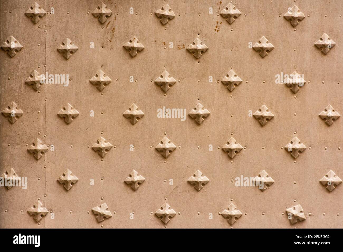 Alte Metalltür mit Kreuz- oder diamantförmigem verzierten Eisen Nägel Stockfoto