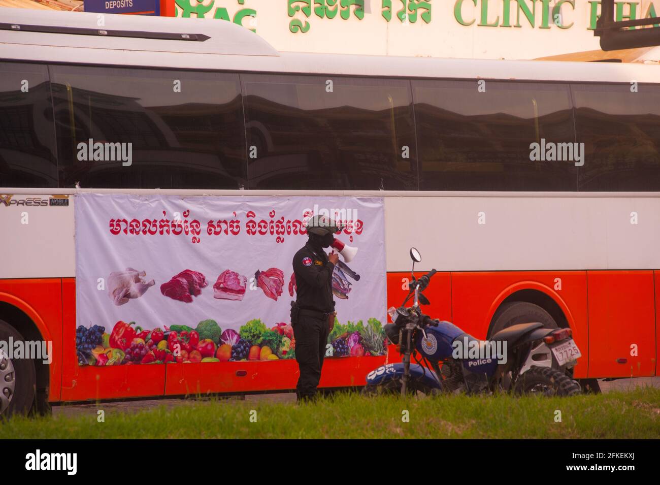 Phnom Penh, Kambodscha. 1. Mai 2021. Aufgrund der jüngsten Ausbrüche von COVID - 19 in Bekleidungsfabriken und -Märkten hat die kambodschanische Regierung eine Sperre auferlegt. Die Regierung hat Stueng Meanchey jetzt als „Rote Zone“ bezeichnet, alles wurde geschlossen, einschließlich Lebensmittelgeschäfte. Die kambodschanische Polizei hat einen Kontrollpunkt in der Nähe eines Regierungsbusses eingerichtet, der dringend benötigte Nahrungsmittelhilfe an arme Familien in den roten Zonen liefert. Viele Kambodschaner befinden sich während der Coronavirus-Pandemie in Quarantäne auf ihren eigenen Straßen. Quelle: Kraig lieb / Alamy Live News Stockfoto