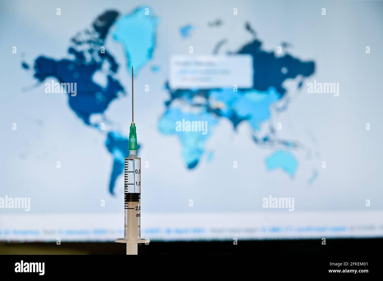 Spritze mit Weltkarte Hintergrund. Der Covid-19-Impfstoff ist ein beliebter Trend auf der weltweiten Agenda Stockfoto