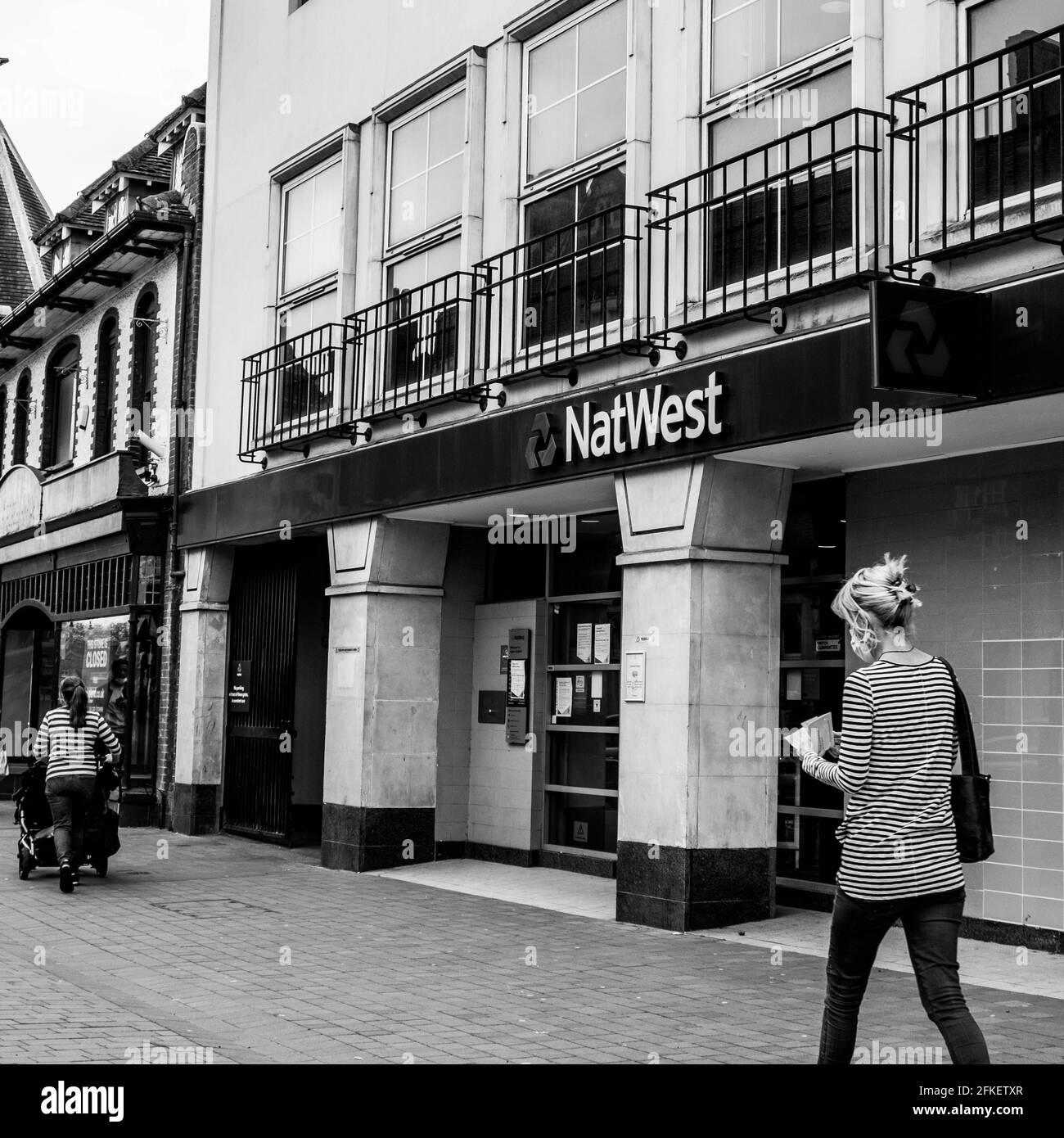 Epsom Surrey London, Großbritannien, April 2021, Frau, die an EINER High Street Filiale der NatWest Bank vorbeiläuft Stockfoto