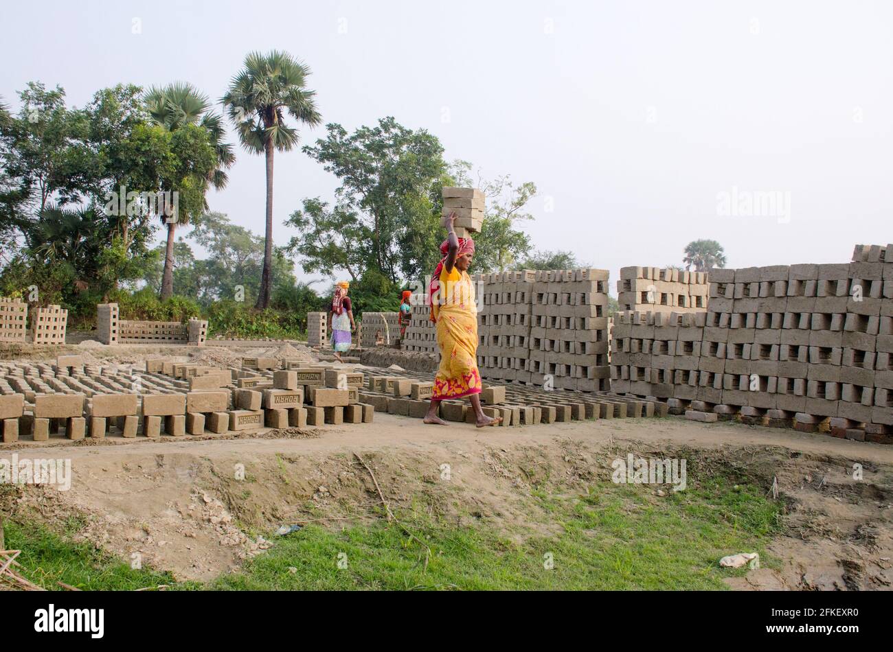 Bild eines Ziegelofens im abgelegenen Hooghly-Viertel. Erwachsene Arbeiter arbeiten hart daran, die rohen Ziegelsteine im Ofen zum Backen zu arrangieren. Stockfoto