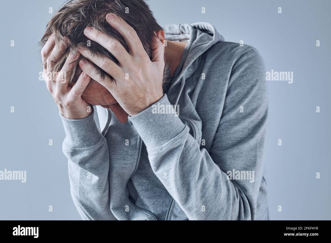 Psychische Gesundheitsprobleme, verstörter depressiver Mann mit Kopf in den Händen, selektiver Fokus Stockfoto