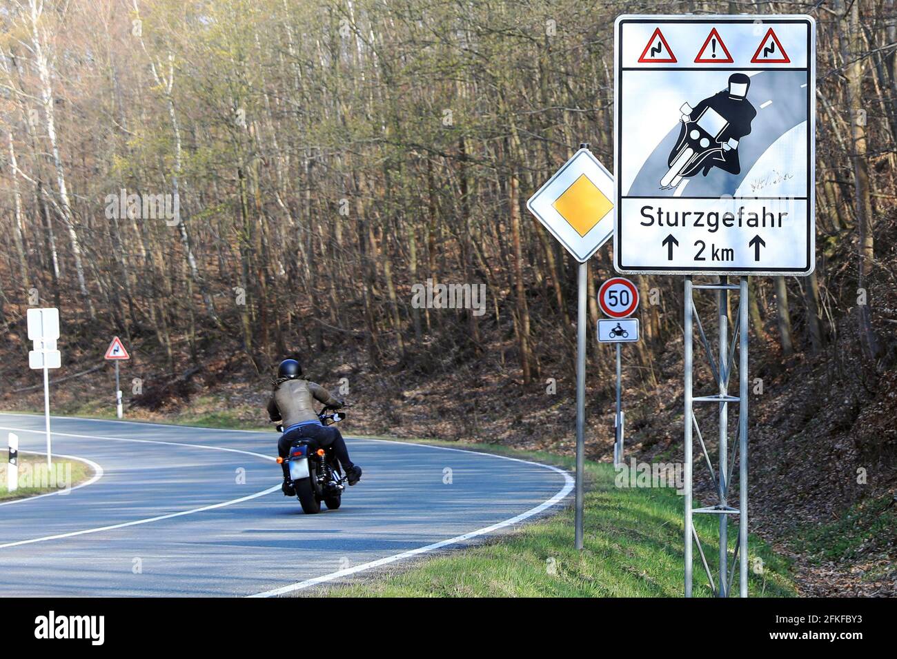 20. April 2021, Sachsen-Anhalt, Blankenburg: Auf einer Landstraße in Richtung Blankenburg steht ein Warnschild für Motorradfahrer "Fallgefahr". In den nächsten Wochen werden viele Motorradfahrer ihre Zweiräder wieder aus dem Winterschlaf holen. Foto: Peter Gercke/dpa-Zentralbild/ZB Stockfoto