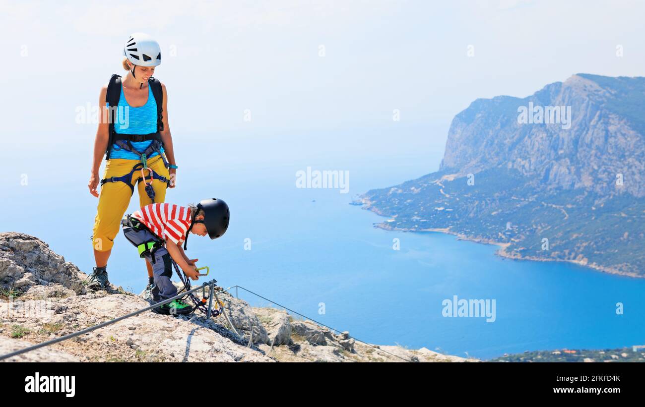 Junge Mutter, Kind in Sicherheitsausrüstung Klettern Sie auf Klettersteig-Anfängerroute zum Gipfel. Familienreise Abenteuer, Kinder wandern Aktivität. Stockfoto