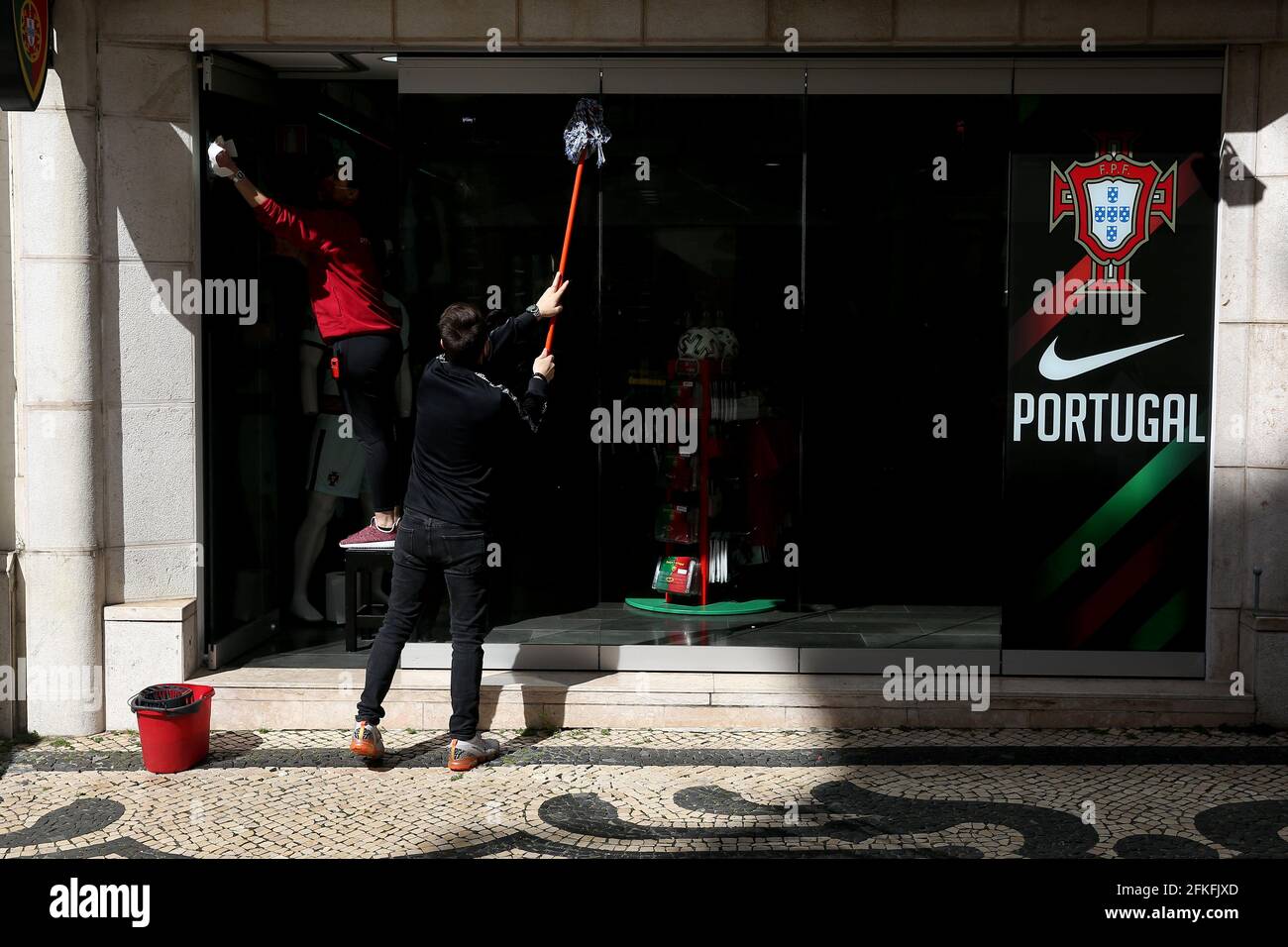 Lissabon, Portugal. Mai 2021. Mitarbeiter reinigen am 1. Mai 2021 ein Schaufenster in Lissabon, Portugal. Die portugiesische Regierung erklärte am Samstag aufgrund der Pandemie von Covid-19 den Zustand der Katastrophe, nachdem der Ausnahmezustand beendet war. Und die vierte Phase der Lockerung der Sperre ohne Einschränkungen der individuellen Freiheiten und Rechte, die nur die Empfehlung von Gesundheitsstandards und einige Einschränkungen für kommerzielle Aktivitäten übrig lässt, wird fortgeführt. Quelle: Pedro Fiuza/ZUMA Wire/Alamy Live News Stockfoto