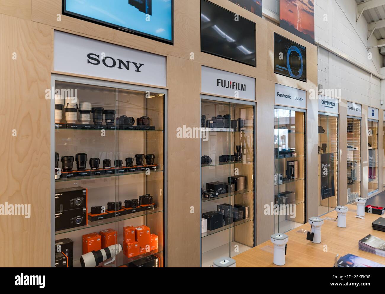 Kamera Store Interieur mit Shop Display von Kameras und Objektiven in Schränken von verschiedenen Kameramarken: Sony, Fujifilm, Panasonic & Olympus Marken Stockfoto