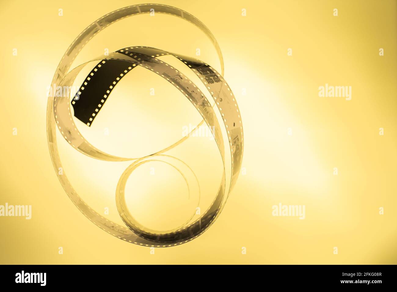 Analoger 35-mm-Negativ-Filmstreifen in Schwarz und Weiß auf dem Lichttisch, Farbe Orange/Gold, Draufsicht mit Kopierbereich Stockfoto