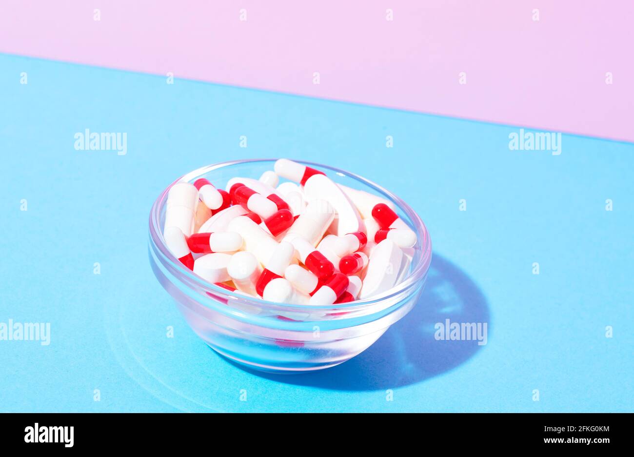 Rote und weiße Kapseln und weiße Pillen in der Schüssel Stockfoto