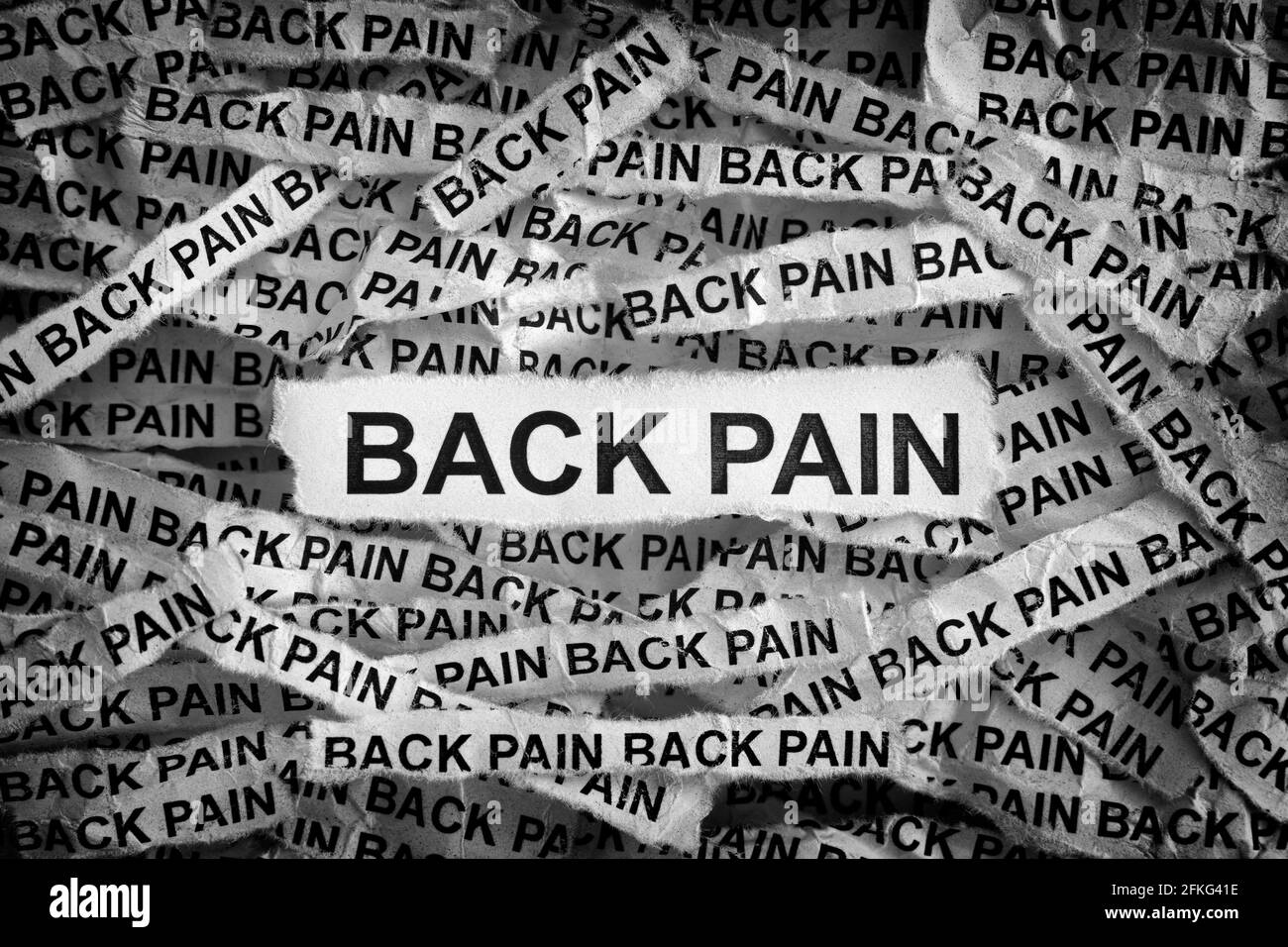Rückenschmerzen. Zerrissene Papierstücke mit den Worten Back Pain. Schwarz und Weiß. Nahaufnahme. Stockfoto