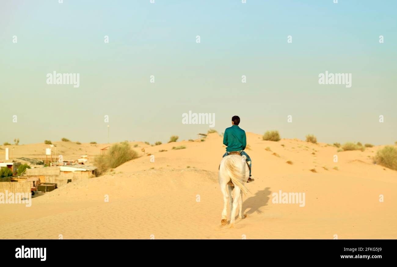 Arabischer Berberhorst in traditioneller Tracht, der über eine Gruppe wacht Von Touristen, die eine Fahrt auf Kamelen durch den Sand Dünen der sahara-Wüste Stockfoto