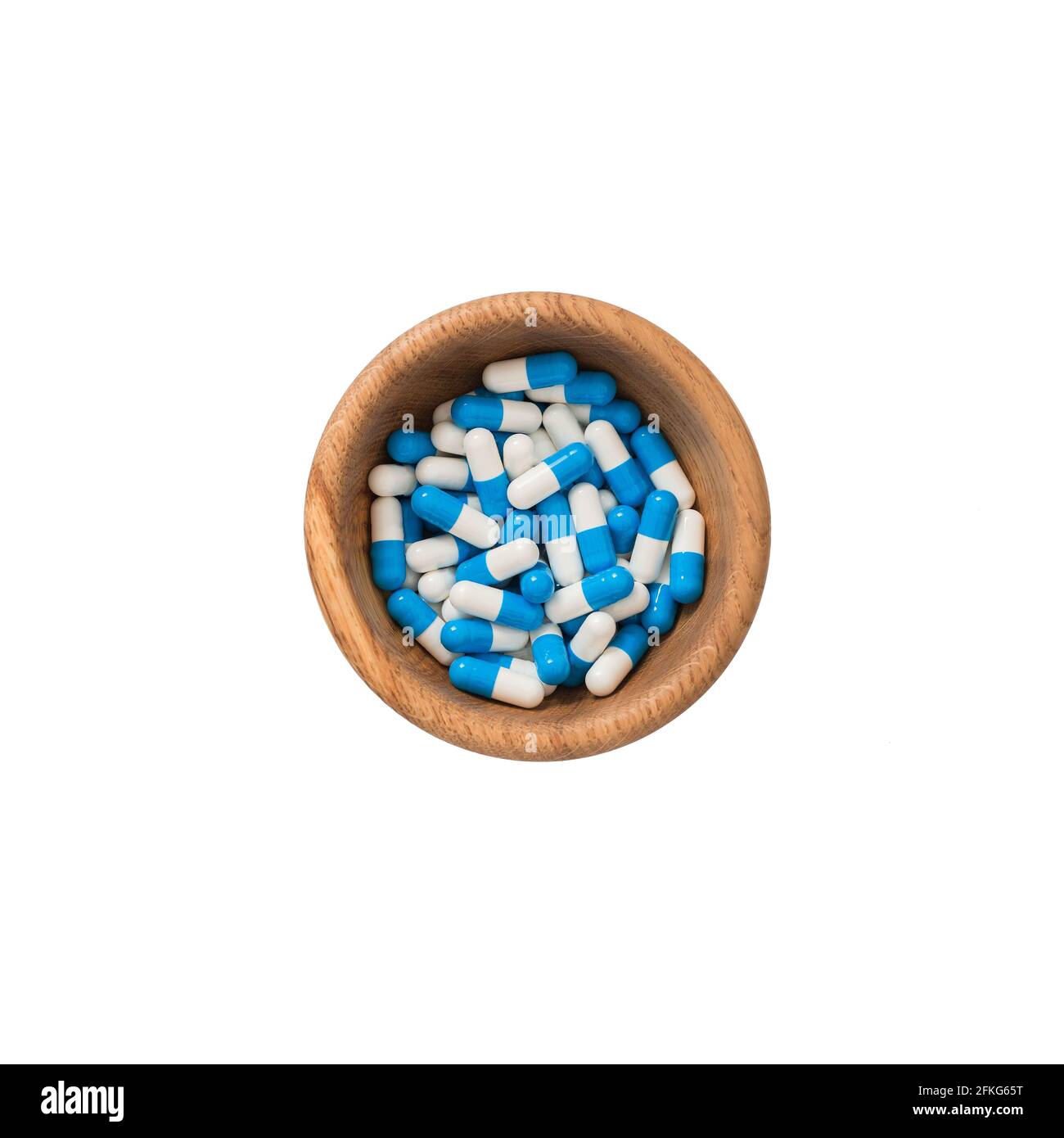 Blaue weiße medizinische Pillen in Holzbecher. Makro-Flatlay-Ansicht. Stockfoto