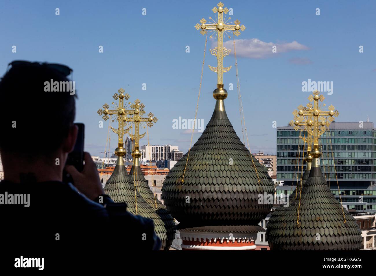 Ein Mann fotografiert Kuppeln der Kirche zu Ehren der Bogoljubskaja Ikone der Gottesmutter im Kloster Vysokopetrovsky in Moskau, Russland Stockfoto