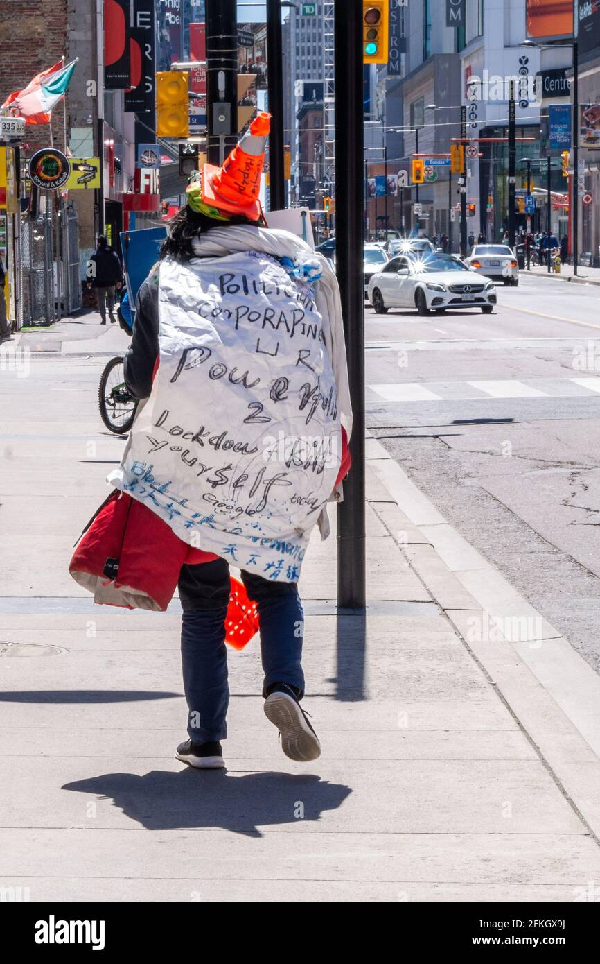 Eine Person, die einen Sack mit Text gegen die Lockdown-Maßnahmen aufgrund der Covid-19-Pandemie trägt. Er wird in der Yonge Street in der Innenstadt von Toronto, Cana, gesehen Stockfoto