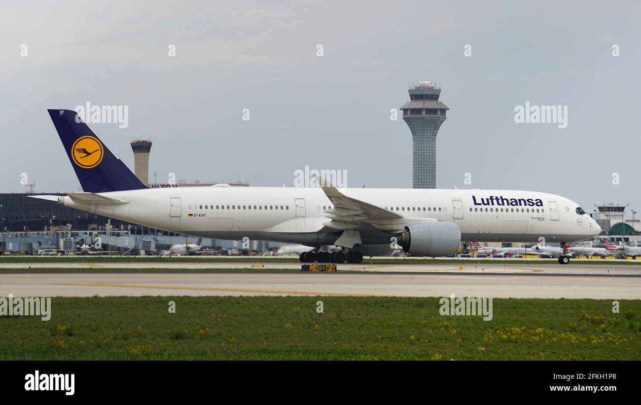 Der Lufthansa Airbus A350 rollt nach der Landung auf dem Chicago O'Hare International Airport auf der Startbahn ab. Der Flugsicherungsturm befindet sich im Hintergrund. Stockfoto