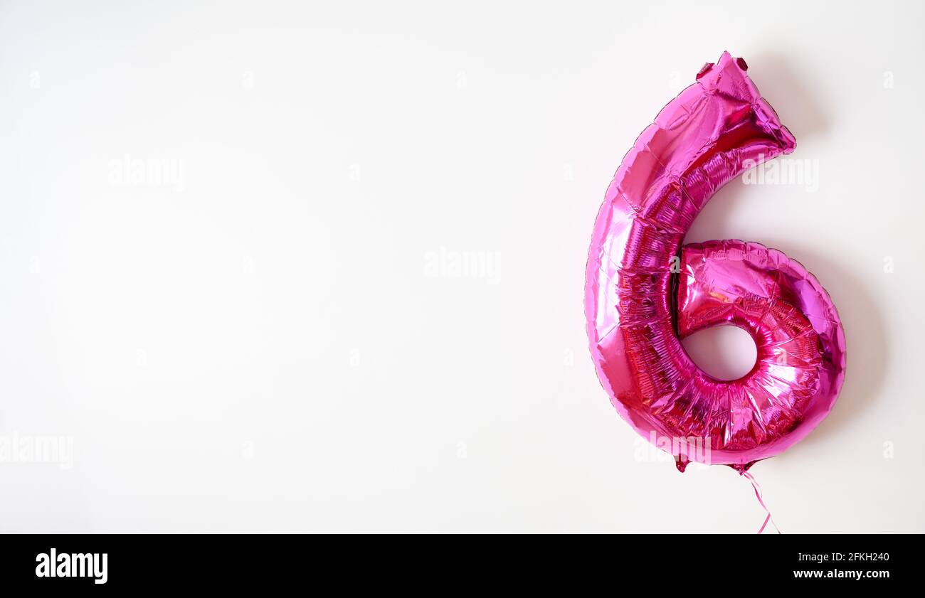 Folienballon Nummer 6 auf weißem Hintergrund, rosa Zahl sechs als aufblasbare Form für Party gemacht. Fliegende Figur 6 und Platz für Text kopieren. Konzept von in Stockfoto