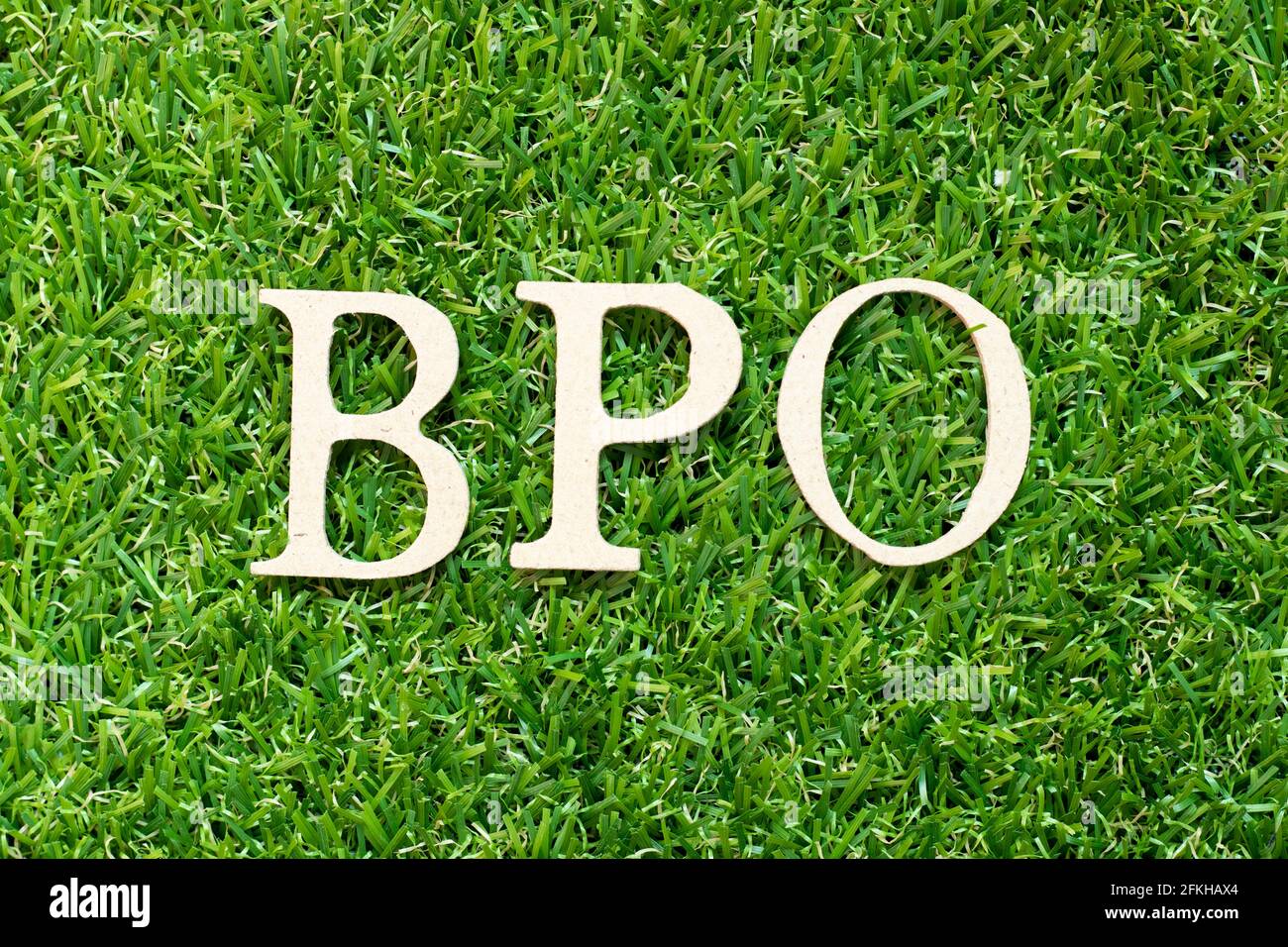 Buchstabe im Wort BPO (Abkürzung für Business Process Outsourcing) Auf grünem Gras Hintergrund Stockfoto