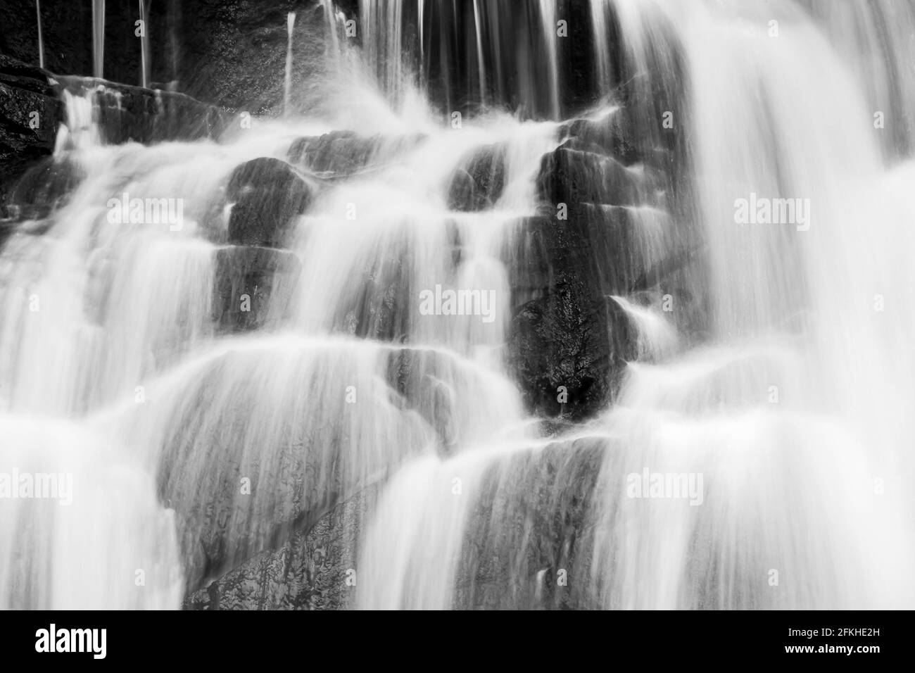 Reiner Wasserfall in einem tropischen Wald, helles und sanft fallendes Wasser aus Abfällen, abstrakte Schichten und Wasserfalloberfläche. Monochrom. Stockfoto