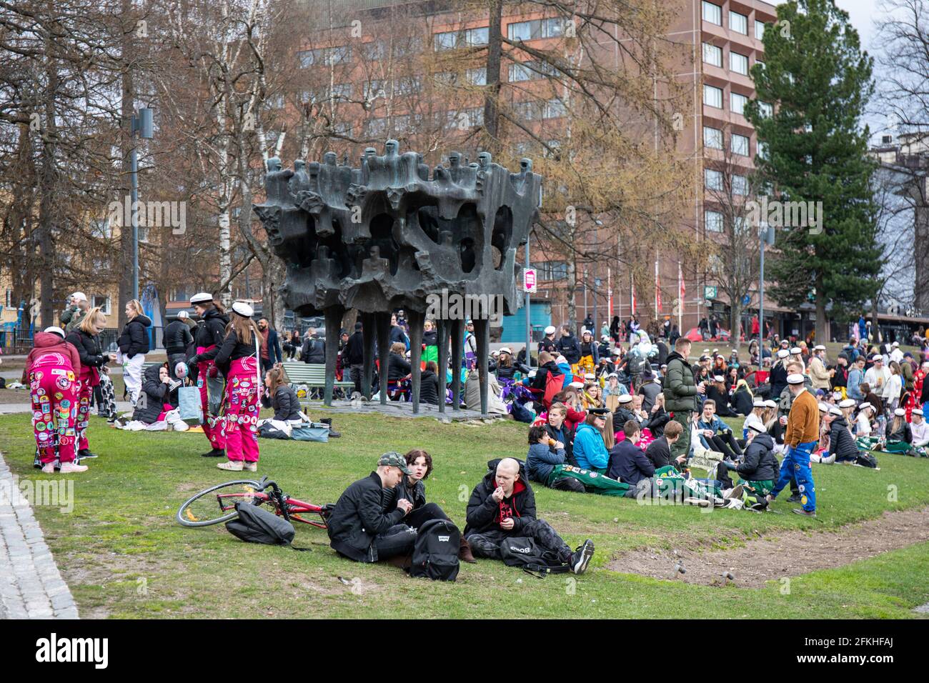 Jugendliche und Studenten - einige in Studentencoveralls - feiern den 1. Mai im Koskipuisto Park in Tampere, Finnland Stockfoto