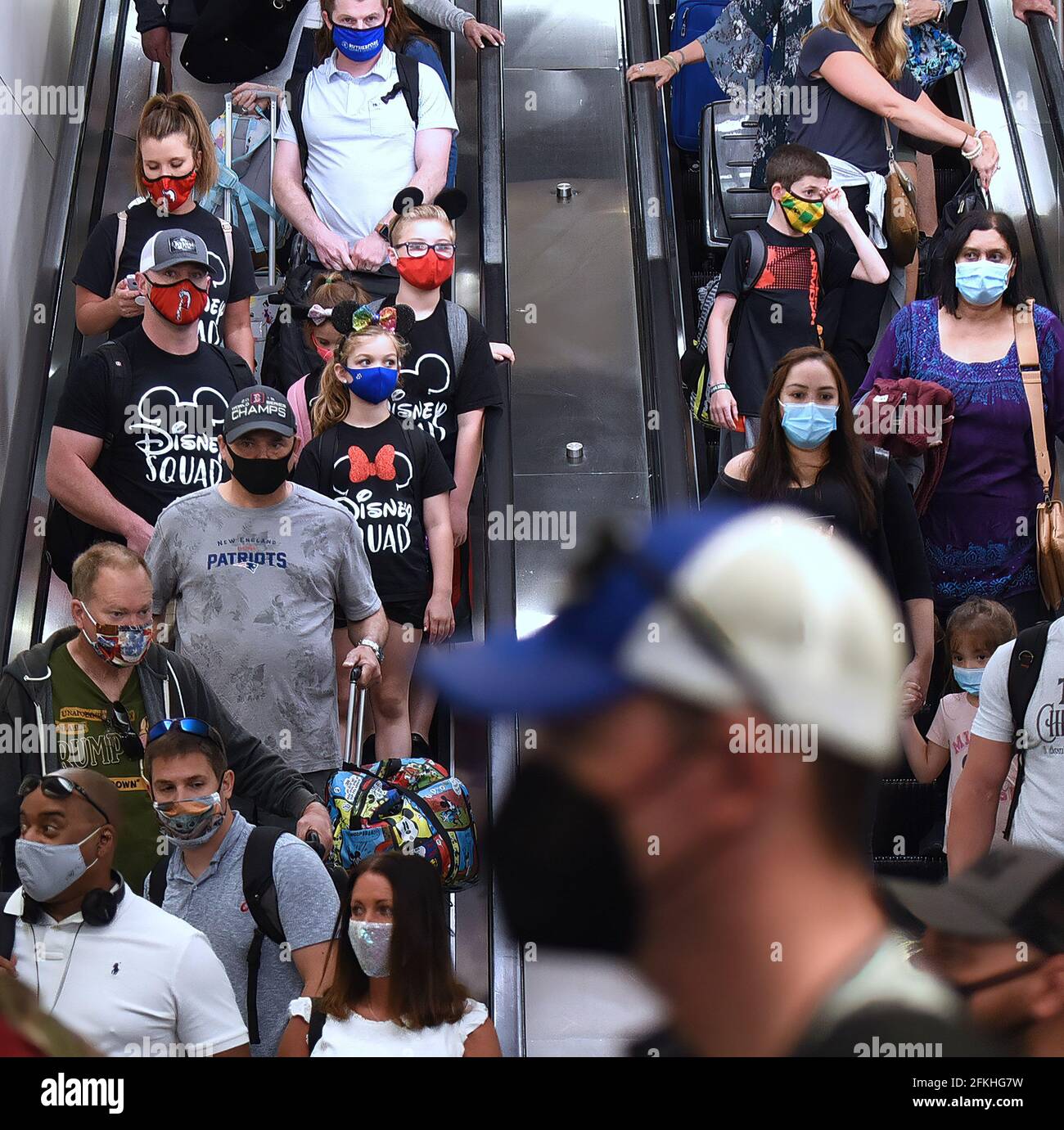 Orlando, Usa. Mai 2021. Passagiere mit Gesichtsmasken als vorbeugende Maßnahme gegen die Ausbreitung von Covid-19 werden auf einer Rolltreppe am Orlando International Airport gesehen. Am 30. April 2021 hat die Transportation Security Administration das Bundesmaskenmandat, das am 11. Mai auslaufen sollte, für alle Fluggäste über 2 Jahren bis zum 13. September verlängert. Kredit: SOPA Images Limited/Alamy Live Nachrichten Stockfoto