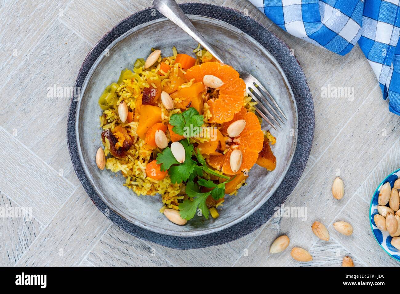 Vegetarischer Pilaf mit Butternusskürbis, Aprikosen, Clementinen und Mandeln Stockfoto