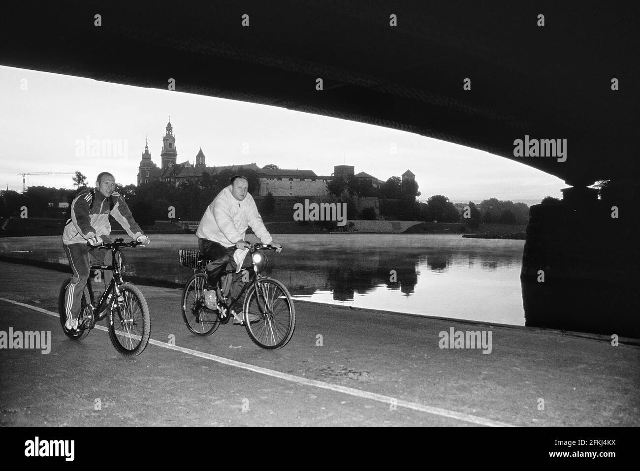 Radfahrer fahren entlang der Czerwieński Boulevard mit Wawel Schloss und Kathedrale im Hintergrund, Krakau, Polen Stockfoto