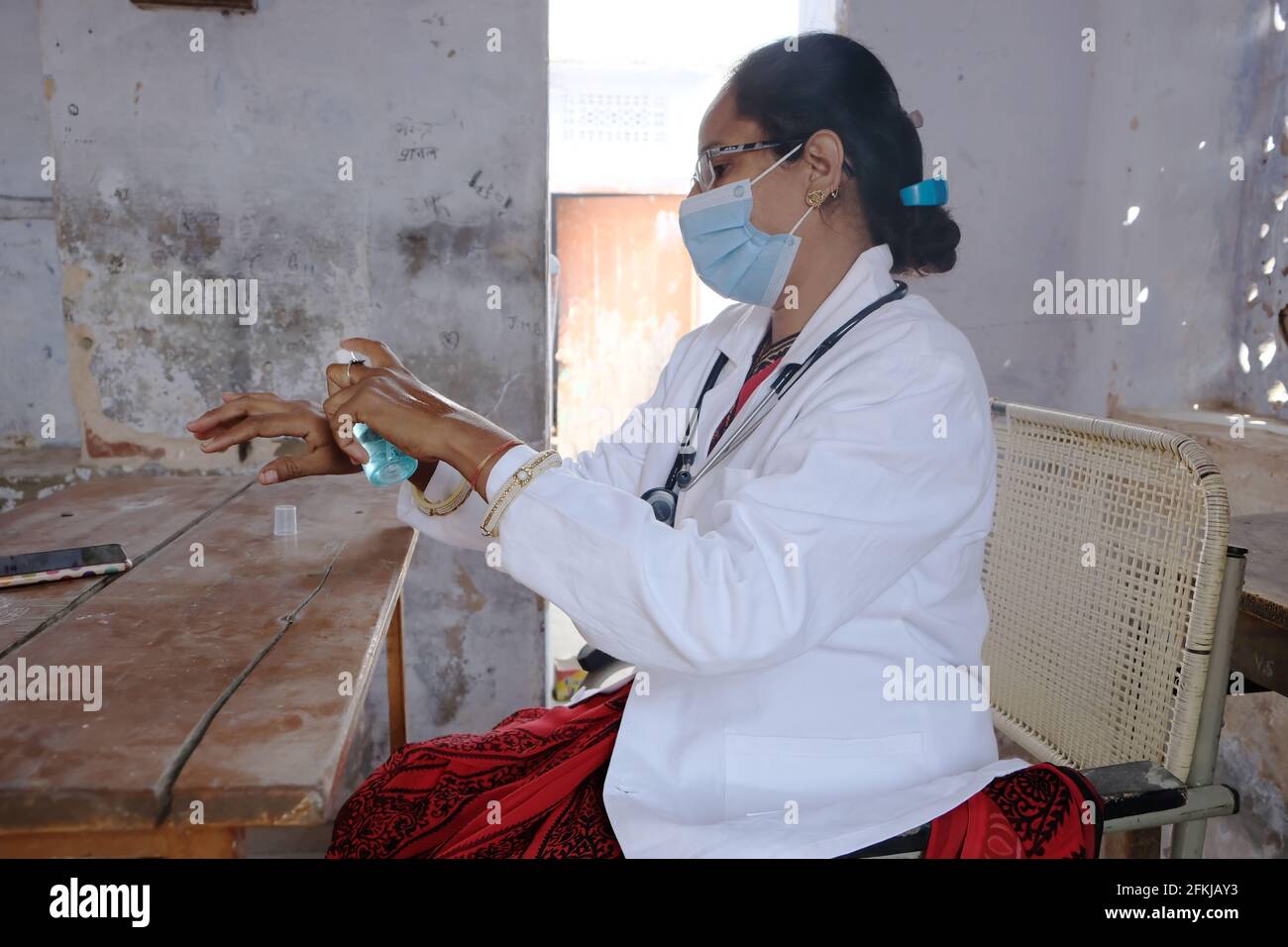 Eine indische Ärztin im medizinischen Bereich, die desinfiziert Hände in der Schule während Covid-19 Stockfoto