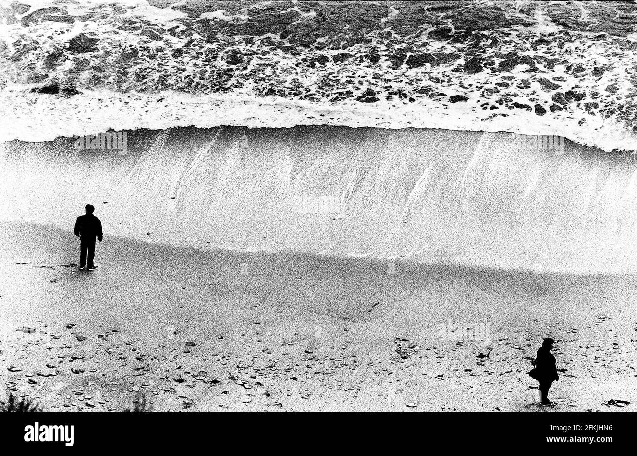 Urlauber spazieren am Strand entlang Cornwall März 1998 Stockfoto
