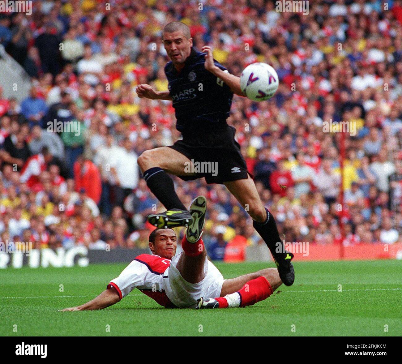 Roy Keane Manchester United Kapitän August 1999 fährt eine Schiebeherausforderung Von Thierry Henry Arsenal während des Sieges des Champions 2-1 bei Highbury Stockfoto