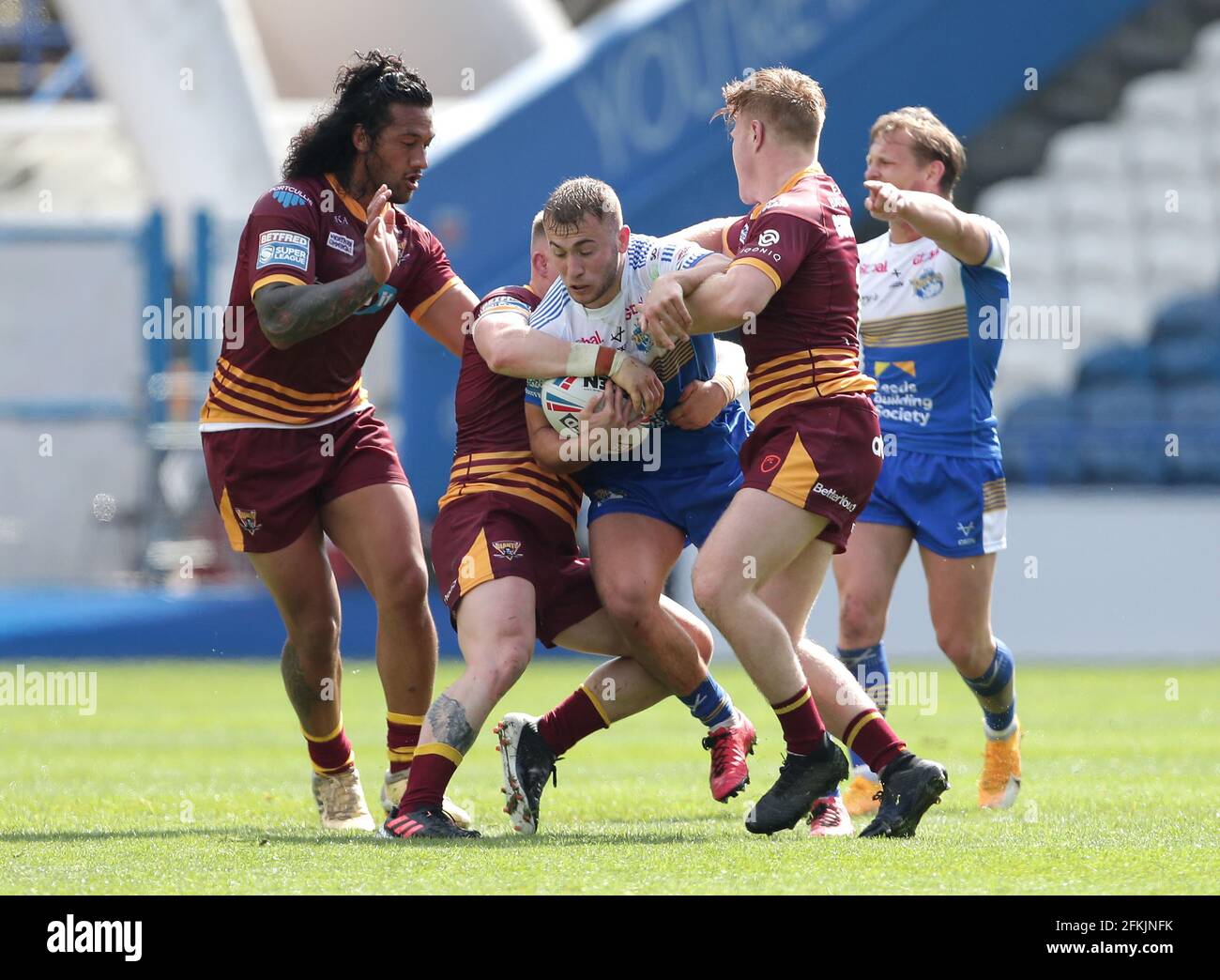 Jarrod O'Connor von Leeds Rhinos (Mitte) wird während des Matches der Betfred Super League im John Smith's Stadium, Huddersfield, angegangen. Bilddatum: Sonntag, 2. Mai 2021. Stockfoto