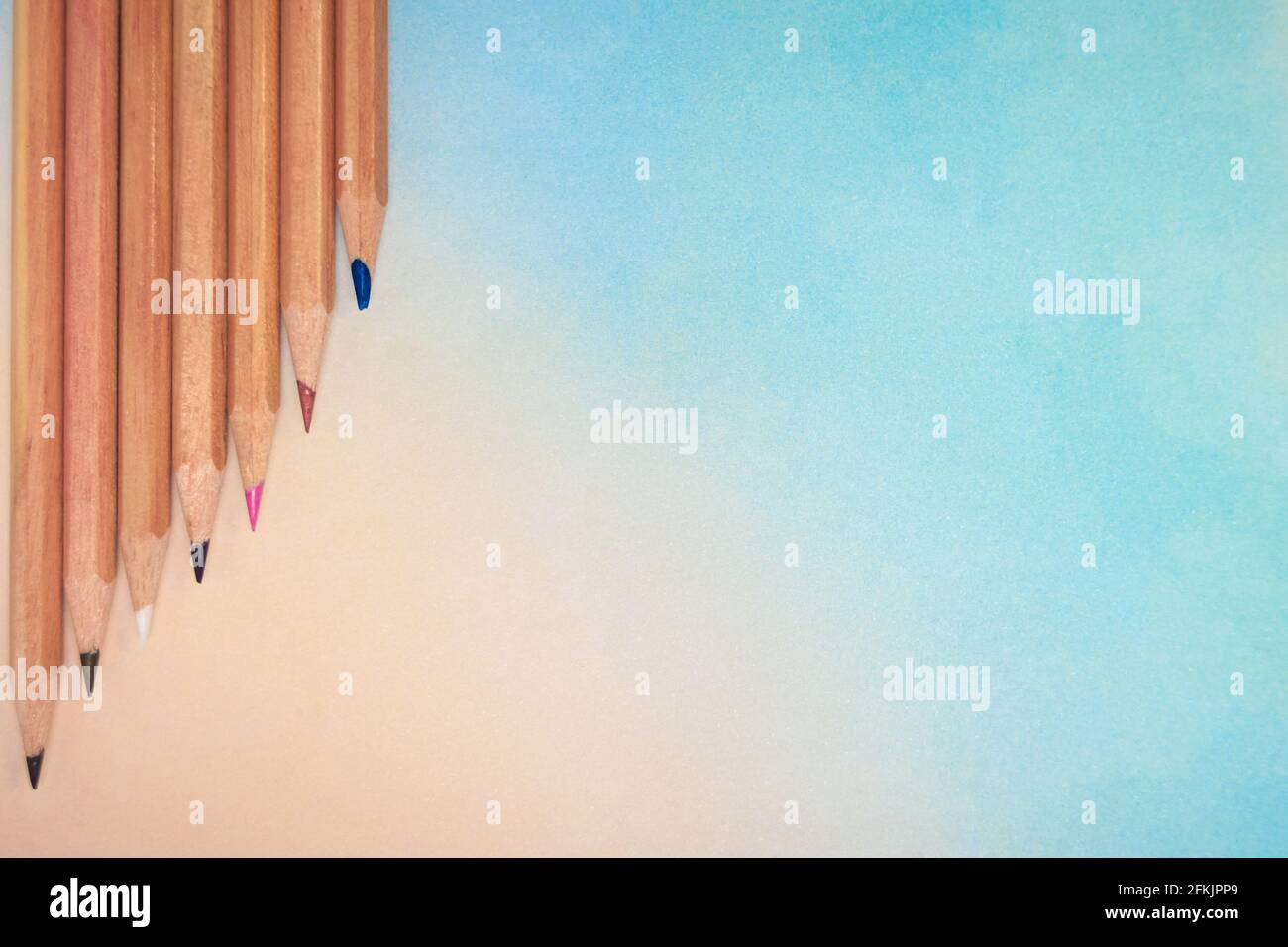 Regenbogenfarbener Hintergrund mit einer Anordnung von Buntstiften. Mit einem großen Textfeld Stockfoto
