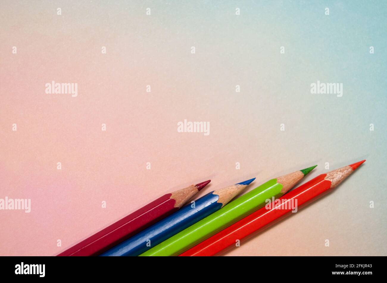 Regenbogenfarbener Hintergrund mit einer Anordnung von Buntstiften. Mit einem großen Textfeld Stockfoto