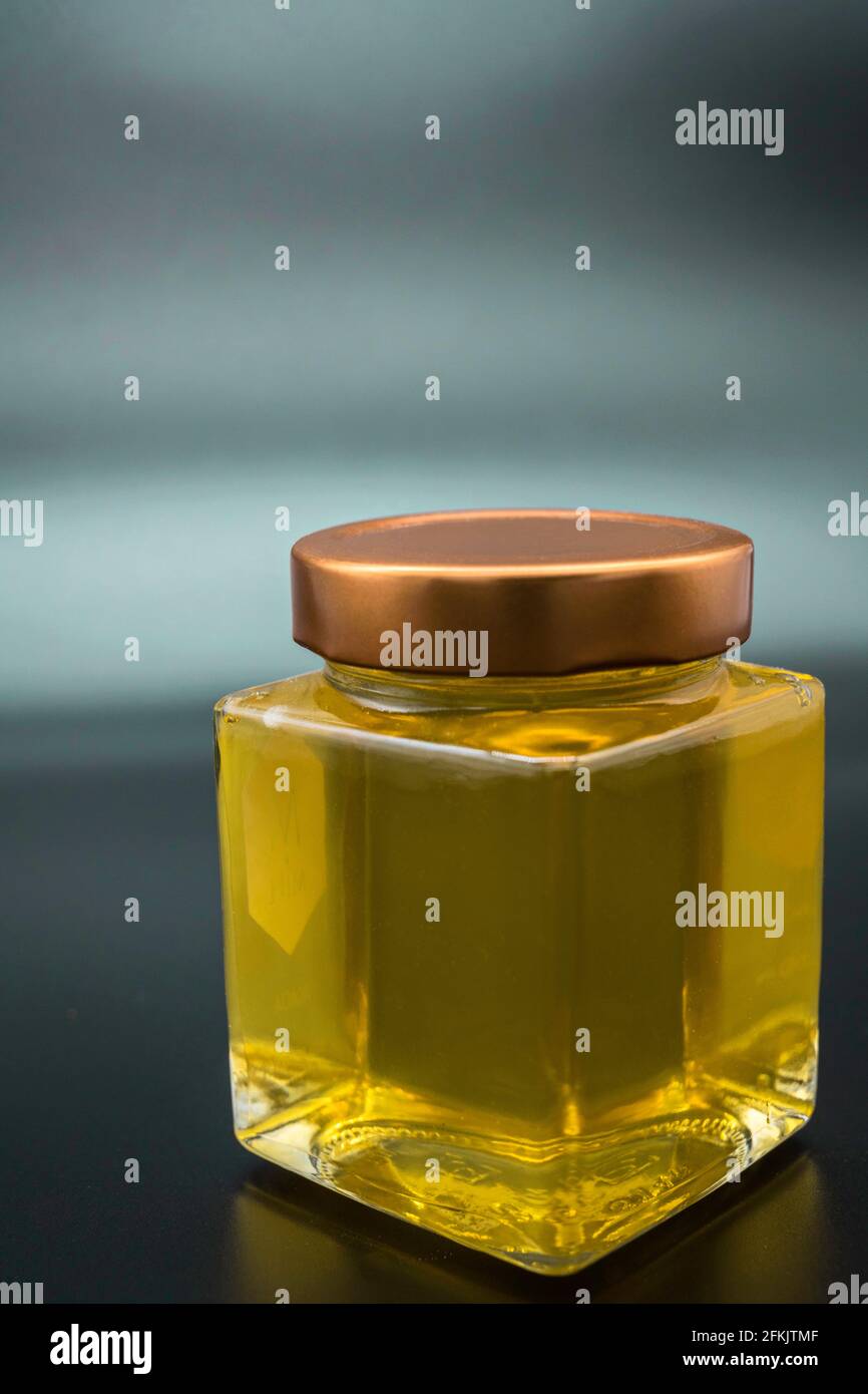 Glas Honig auf schlichtem dunklen Hintergrund Stockfoto