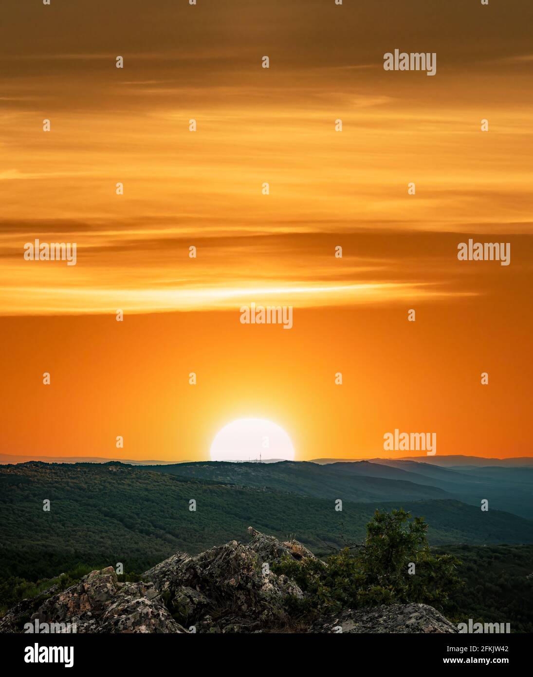Orangefarbener Sonnenuntergang mit Textbereich über der Bergkette Stockfoto