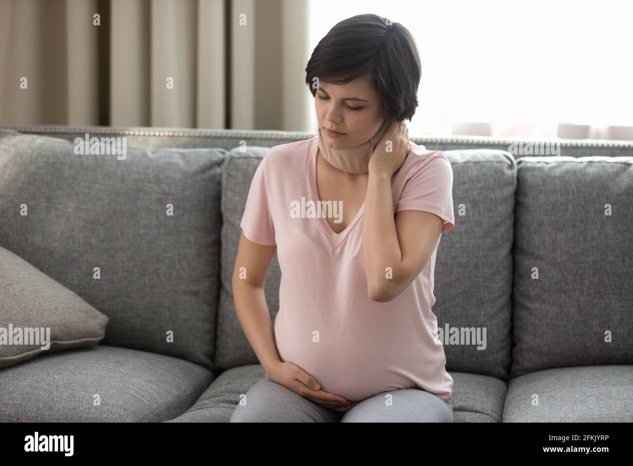 Eine ungesunde Schwangerin leidet unter Nackenschmerzen Stockfoto