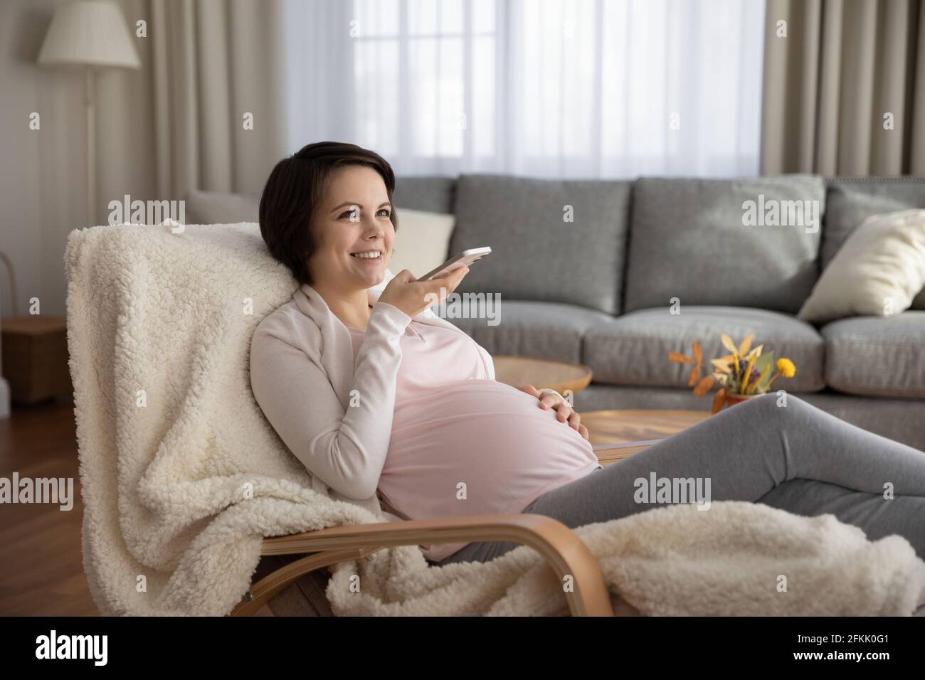 Glückliche Schwangeren nehmen Audio auf Handy auf Stockfoto