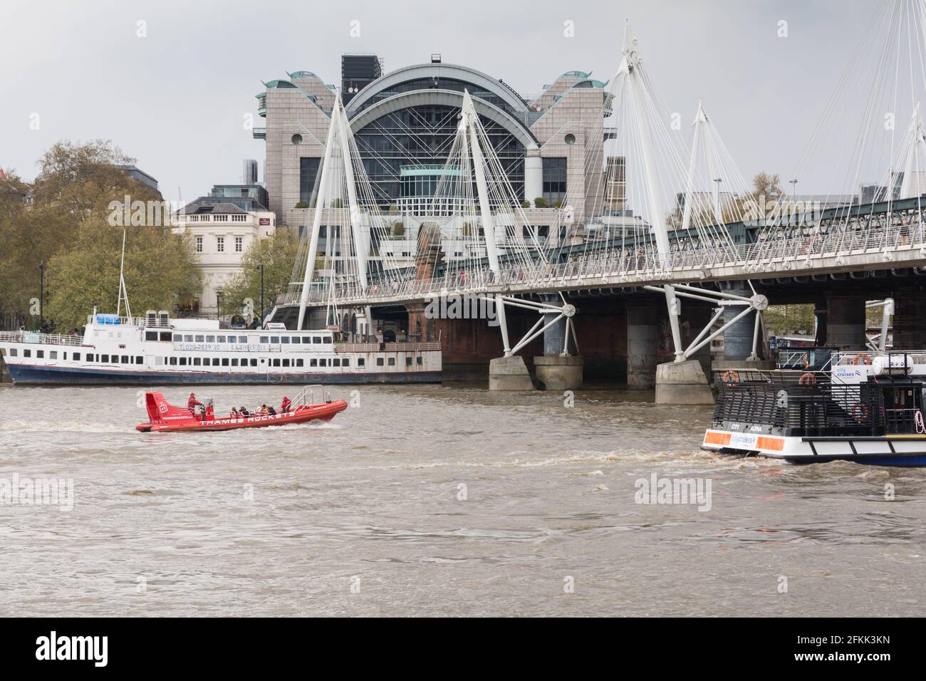 Ein Boot mit der Thames Rocket Rib fährt in der Nähe der Charing Cross Station und der Golden Jubilee Footbridge und der Hungerford Bridge, Waterloo, London, England, Großbritannien Stockfoto