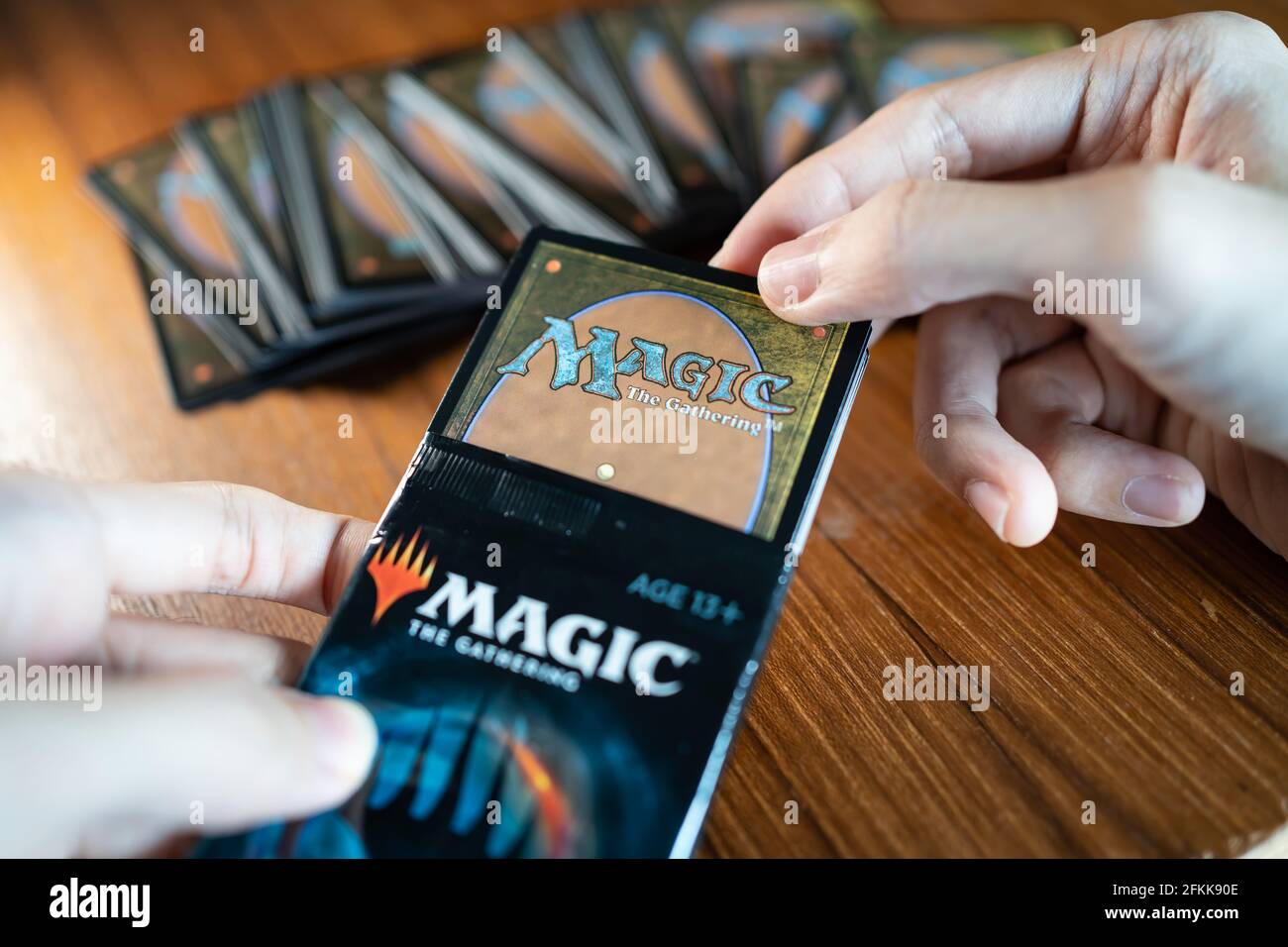 Bangkok, Thailand - 2. Mai 2021 : EIN Mann öffnet Magic the Gathering Card Booster Pack. Stockfoto