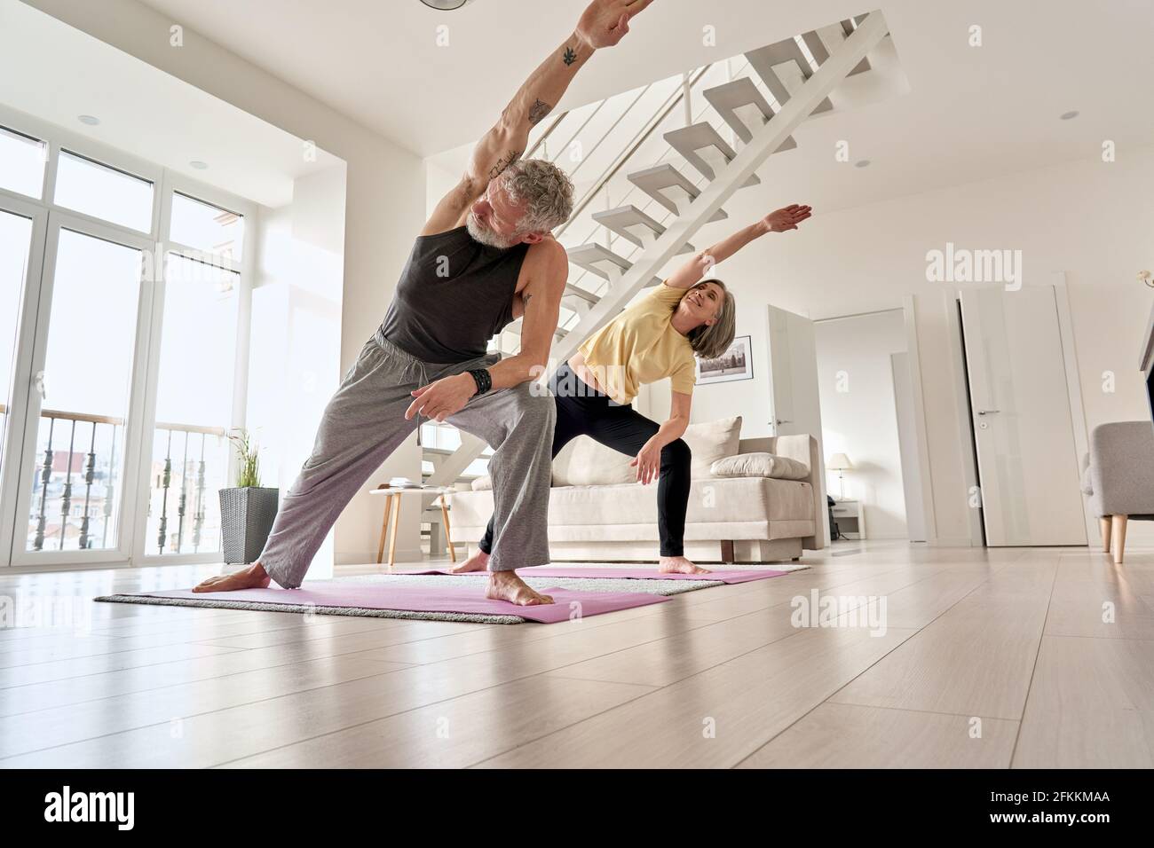 Fit mittleren Alters Familienpaar macht Fitness-Morgen-Training zu Hause. Stockfoto