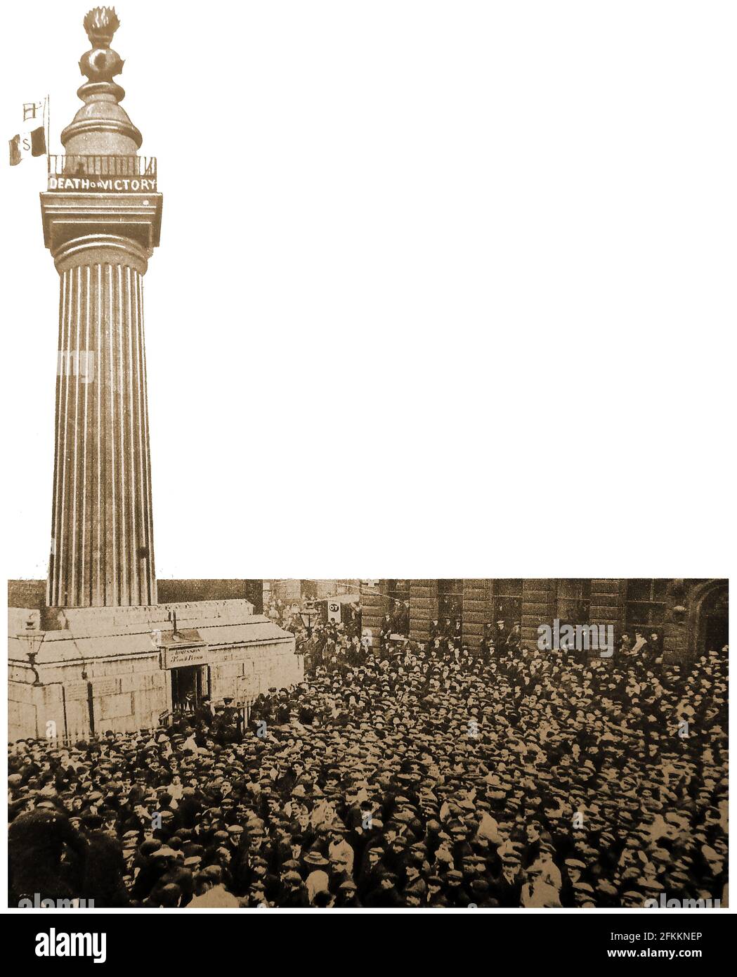 1913 - Suffragettes besteigen illegal das Londoner Monument, das an das große Feuer Londons erinnert, um ein Transparent mit der Aufschrift „Tod oder Sieg“ zu entrollen. Menschenmassen versammelten sich, um ihre Erfolge zu sehen. Stockfoto