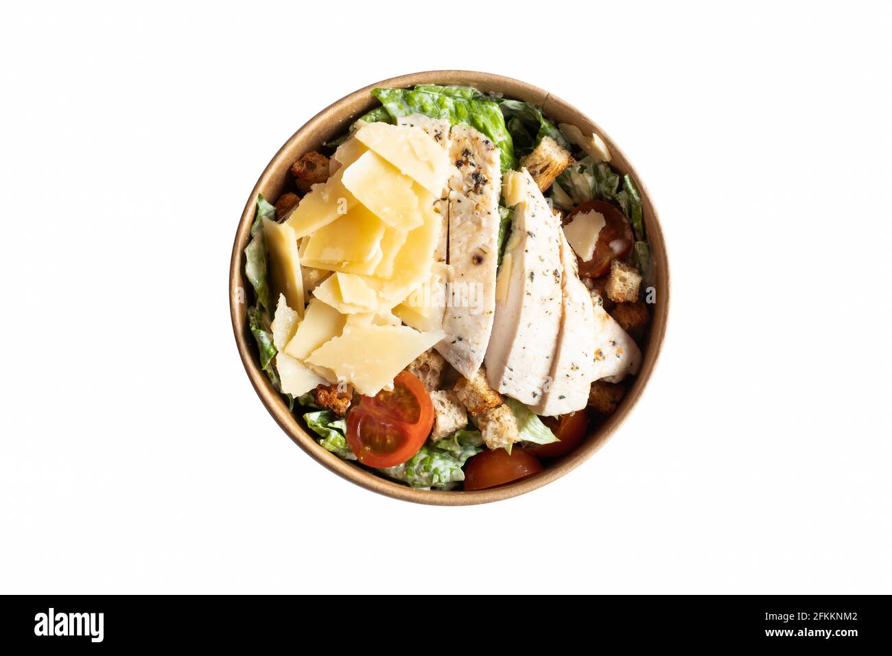 Caesar Salat isoliert. Köstlicher frischer Hähnchensalat in einem runden braunen Lebensmittelbehälter. Stockfoto