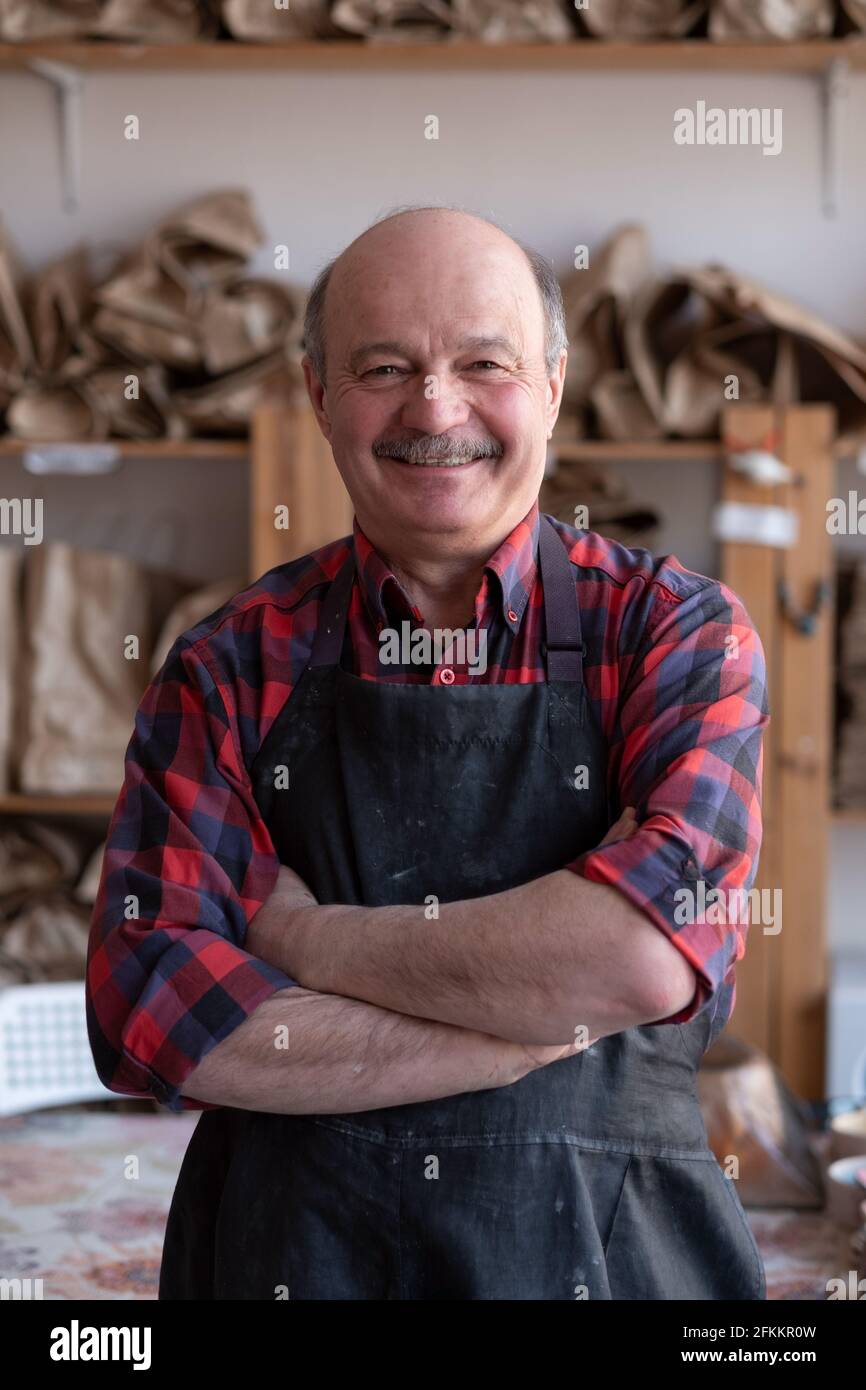 Ein glücklicher hispanischer Handwerker, der im Studio steht. Stockfoto