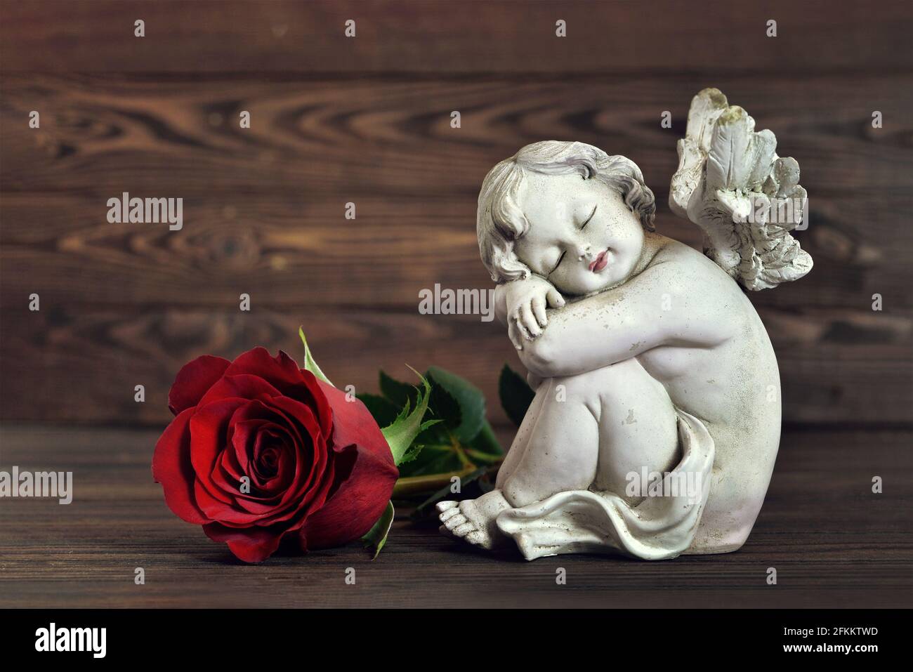 Engel und rote Rose auf dem Buch Stockfotografie - Alamy