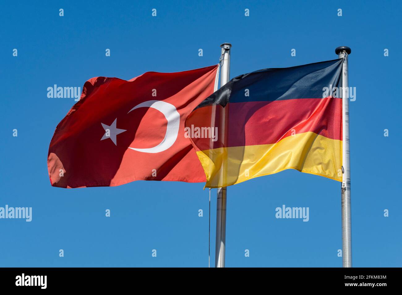 Deutsche und türkische Flaggen gegen blauen Himmel Stockfoto