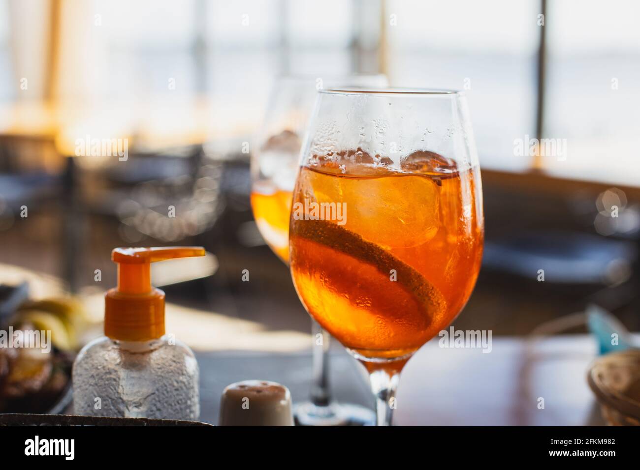 Ein Glas kaltes Getränk und ein antibakterielles Mittel in Ein Stadtcafe Stockfoto