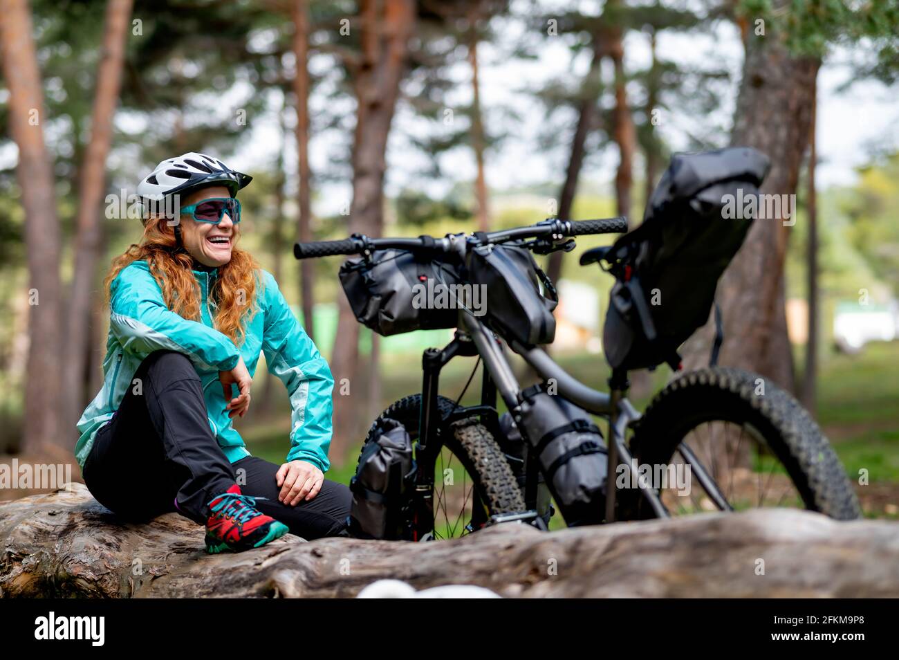 Eine Frau neben ihrem abenteuerlich ausgerüsteten Fahrrad Stockfoto