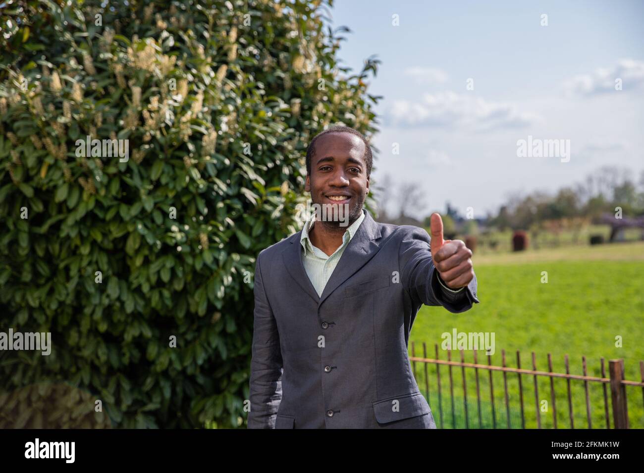 Ein glücklicher afroamerikanischer Geschäftsmann macht im Freien eine Geste des Aufprall Stockfoto