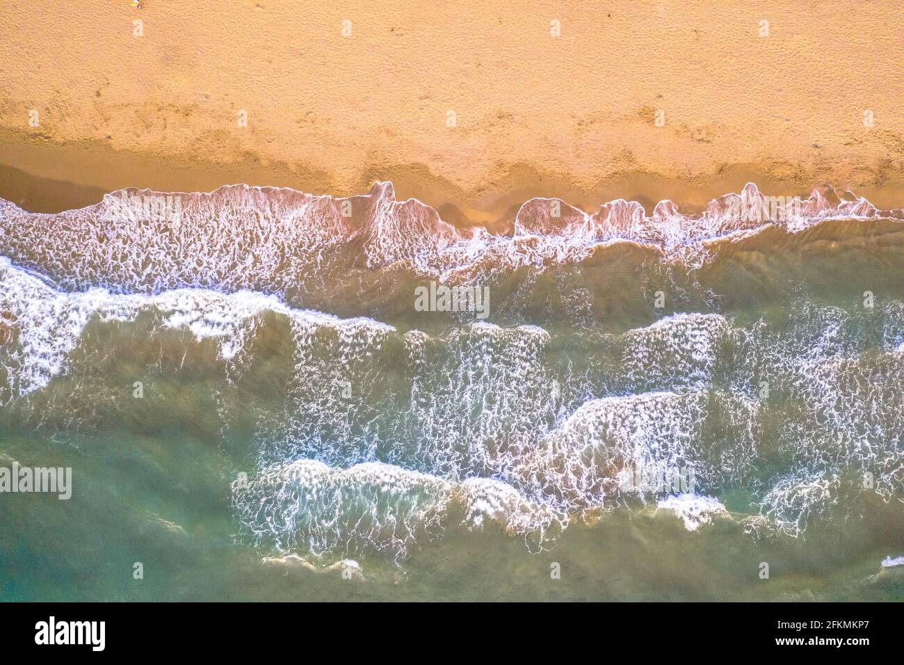 Von oben Blick auf die Meereswellen des Wassers am goldfarbenen Strand von Korsika, Frankreich. Stockfoto